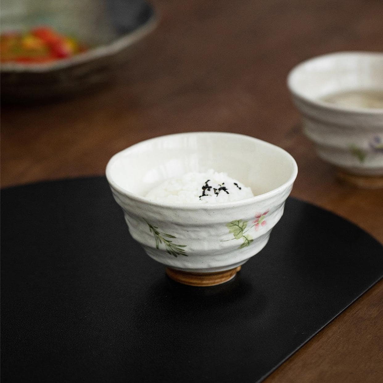 Pair of artisan floral ceramic bowls against neutral background