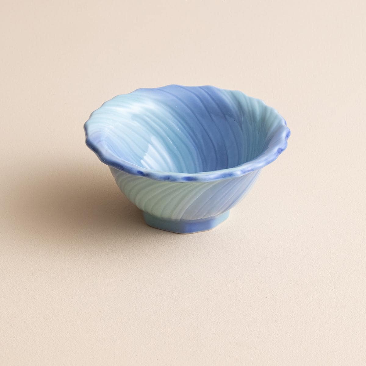 Close-up of flower-shaped ceramic bowl showcasing swirling glaze patterns.