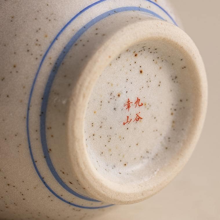 Handcrafted ceramic cup with sparrow and cherry blossom design.