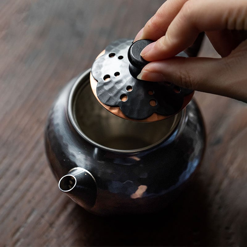 Close-up of the elegant lid design on a copper kettle