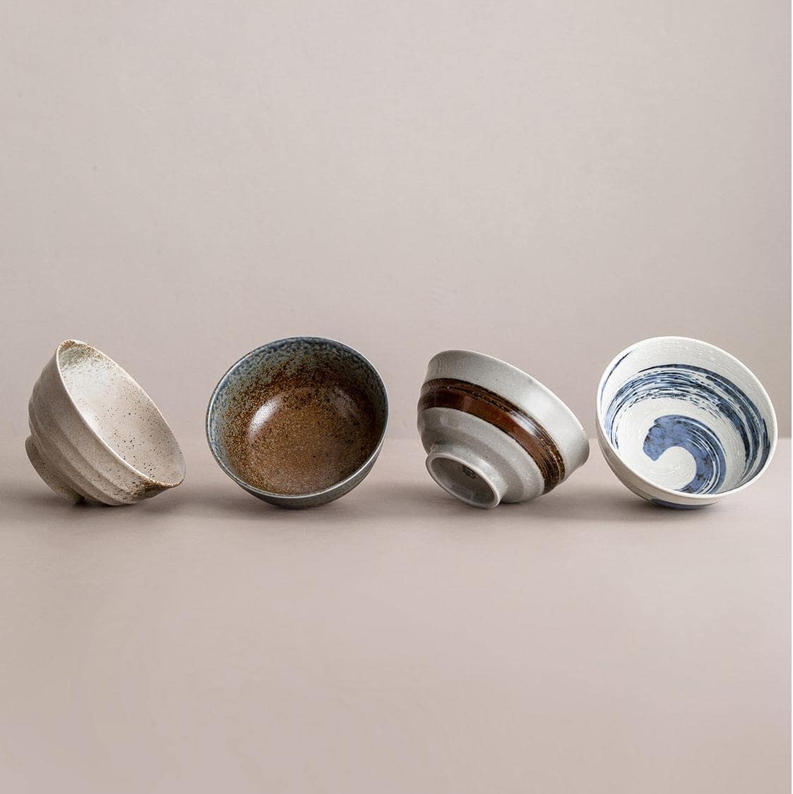 Collection of handcrafted ceramic bowls in various patterns and colors