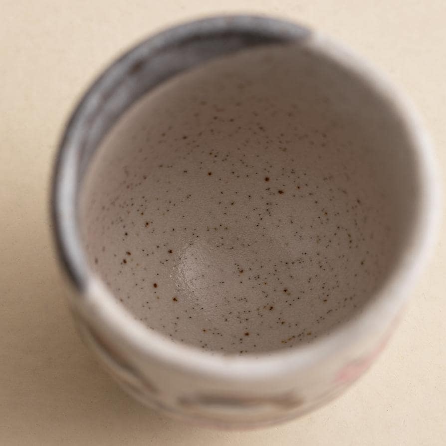 Close-up of hand-painted sparrows on a ceramic tea cup.