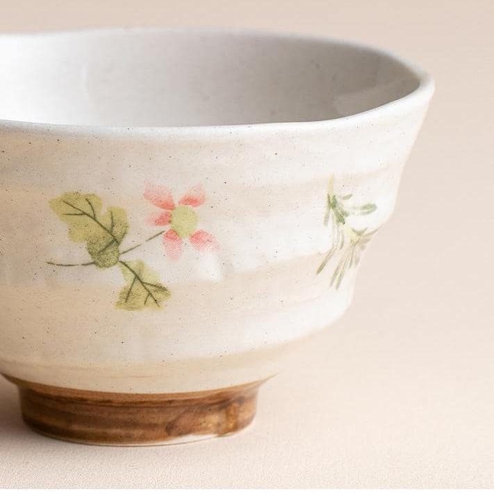 Pair of artisan floral ceramic bowls against neutral background