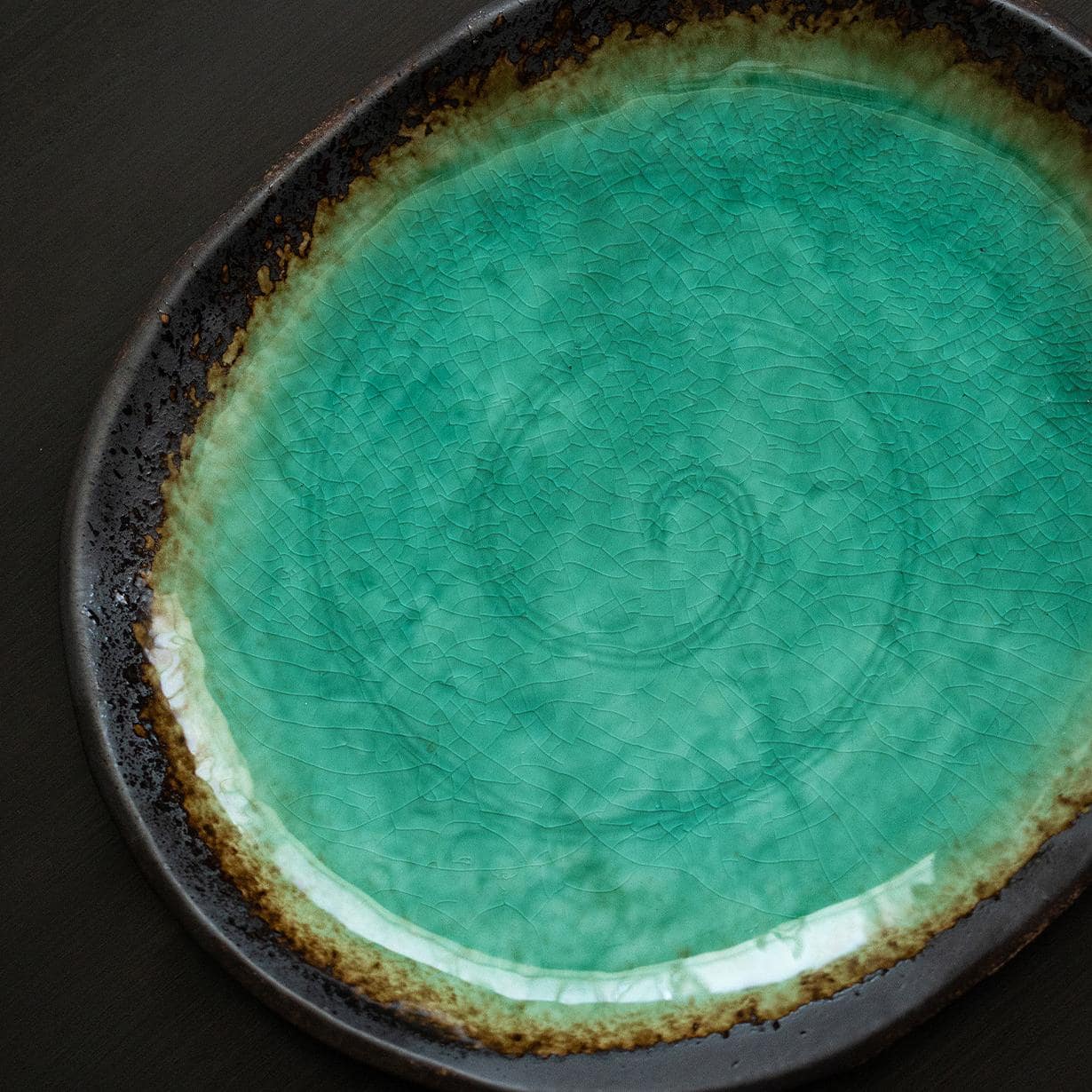 Handcrafted green glazed ceramic plate in turquoise