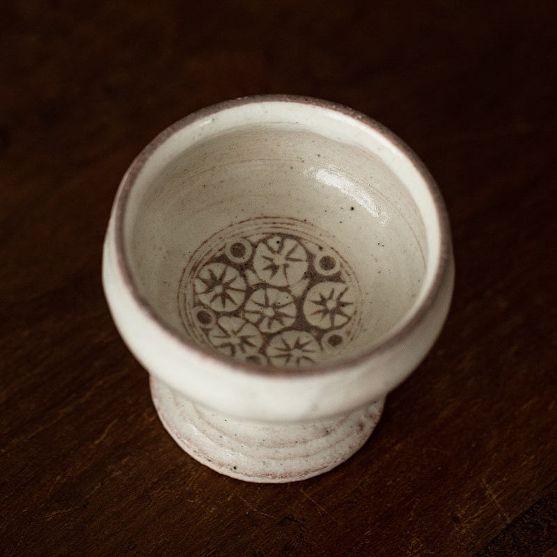 Artisan ceramic cup with a pedestal base and unique pattern