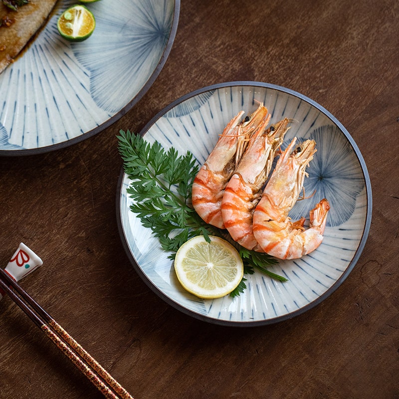 Blue floral patterned plate with shrimp and lemon garnish