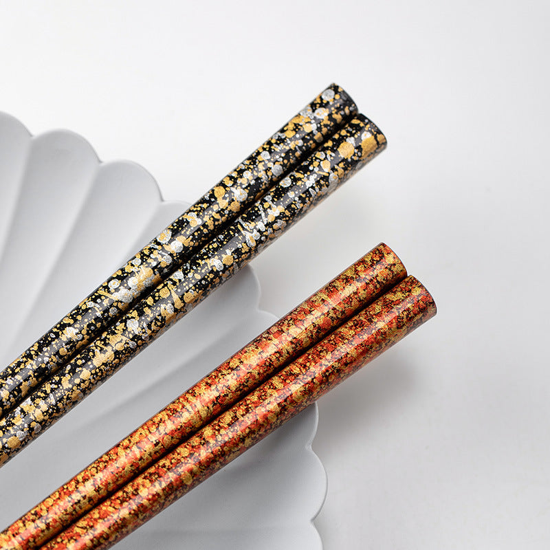 Single set of lacquered chopsticks with intricate gold design