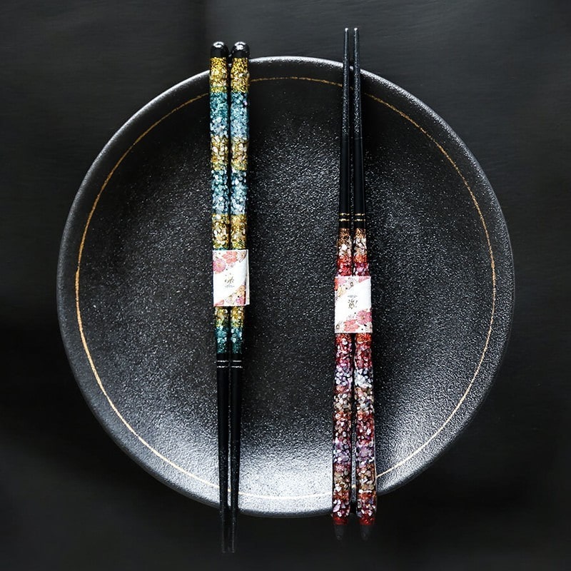 Luxurious black chopsticks with gold and red detailing.
