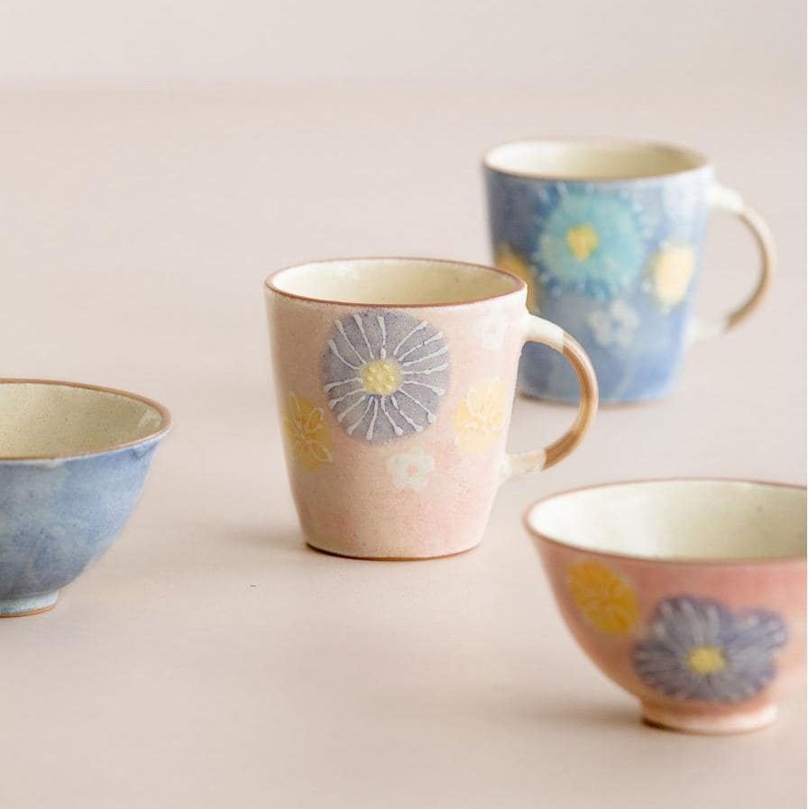 Set of artisan ceramic cups showcasing colorful gradients and floral details