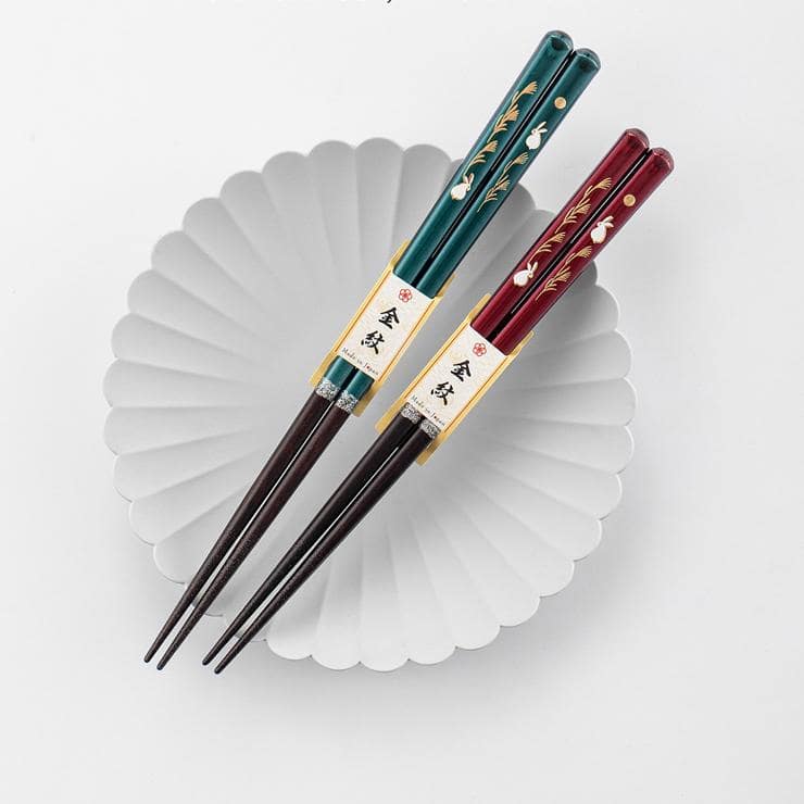 Two pairs of Japanese rabbit-themed solid wood chopsticks on a white background.