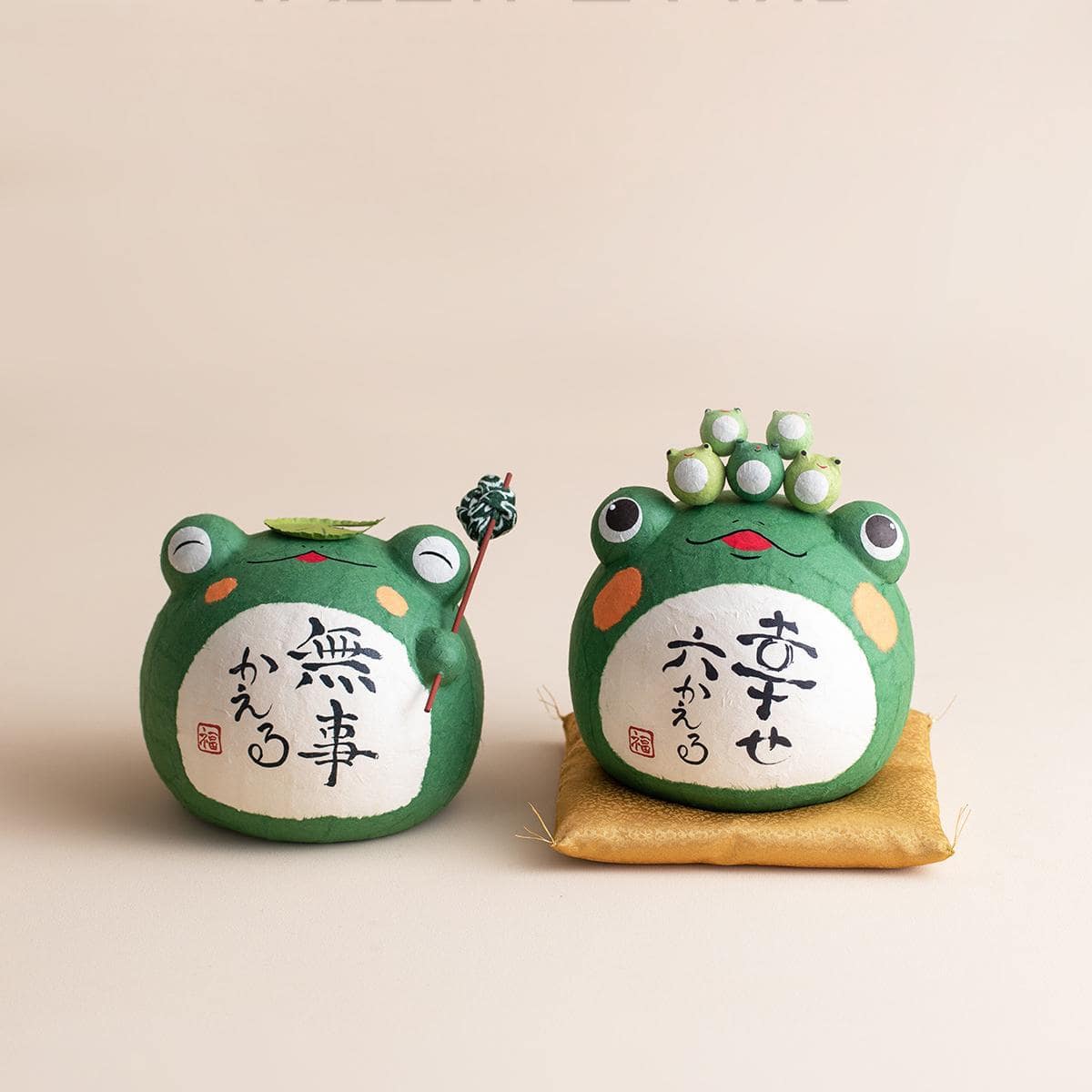 Handcrafted Japanese Longhutang Peace Frog ceramic ornament on a golden cushion.