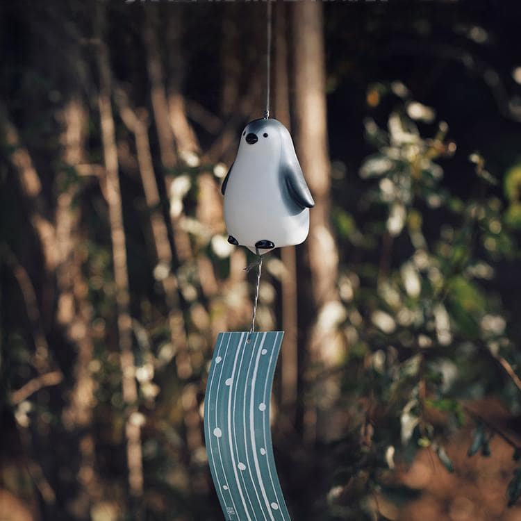 Ceramic bear wind chime with soft blue accents.