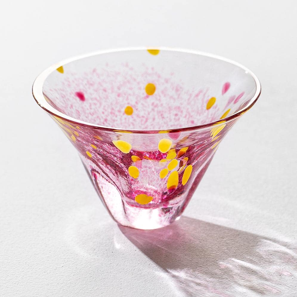 Handcrafted glass cups in pink, blue, and aqua on a white surface