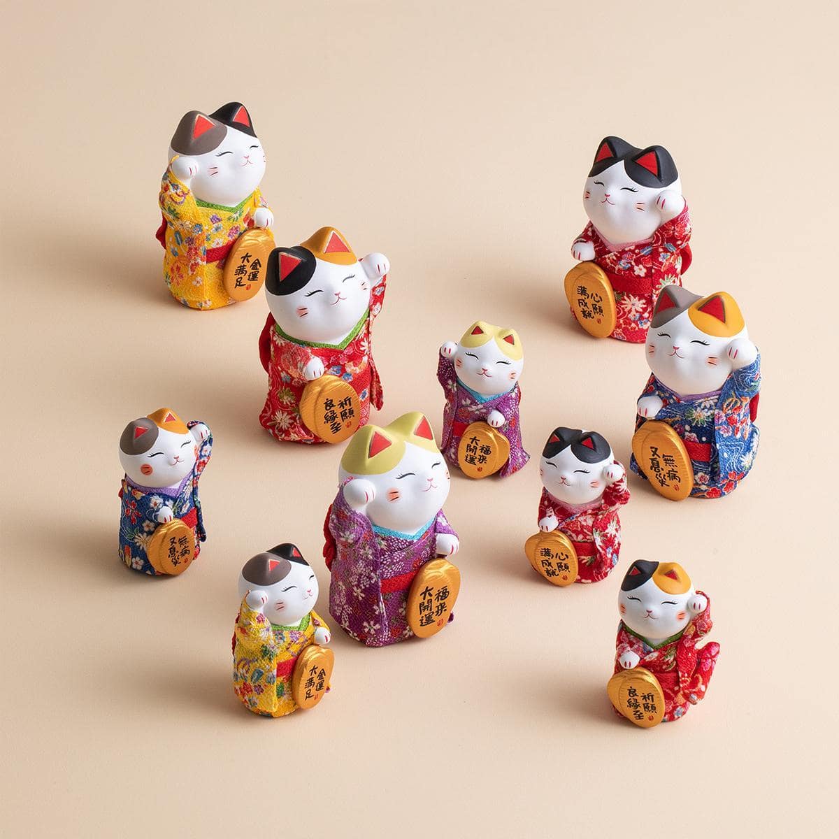 Japanese ceramic lucky cat figurine in a red kimono on a wooden table.