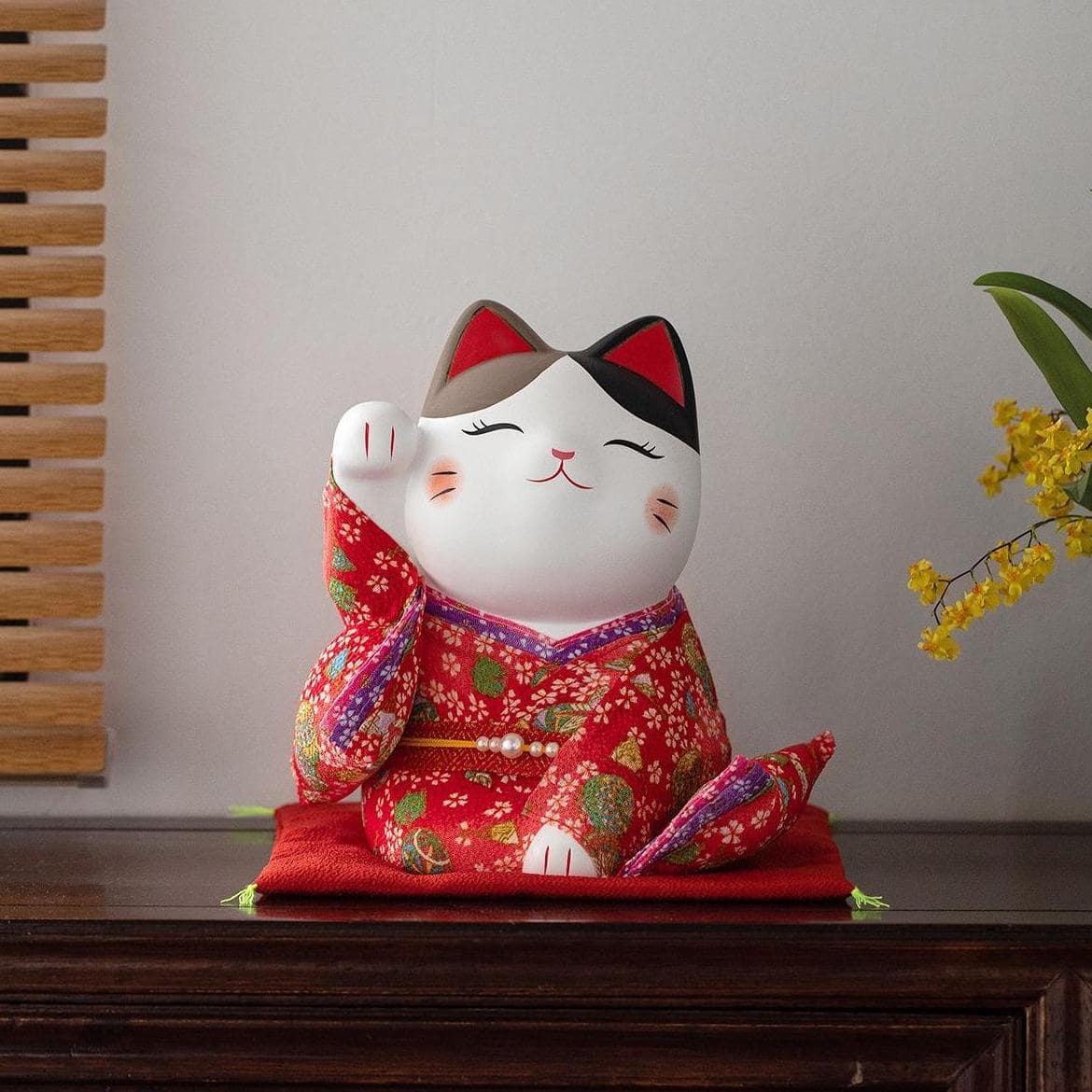 Ceramic lucky cat ornament dressed in a yellow floral kimono