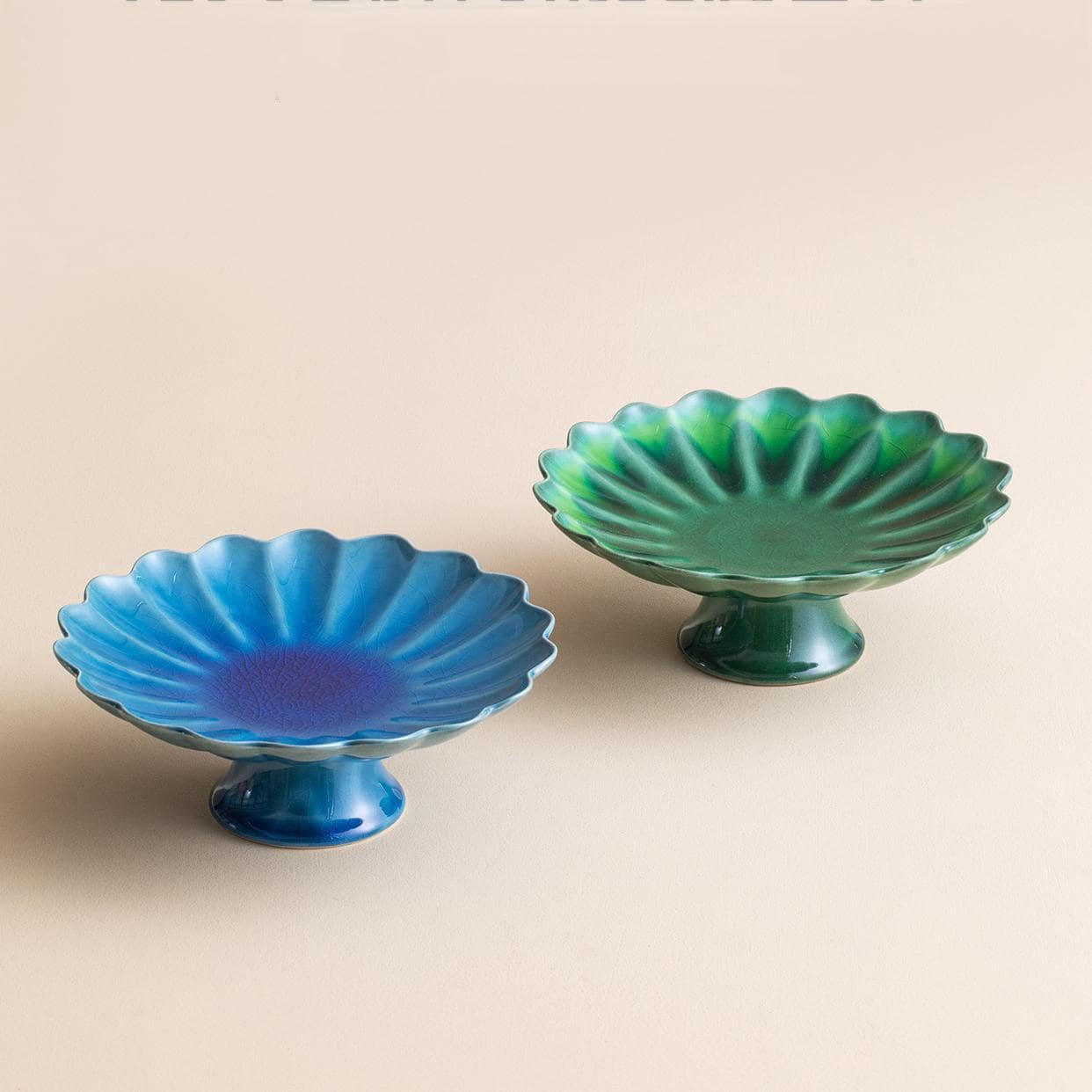 Elevated green ceramic plate with pedestal design for serving desserts.