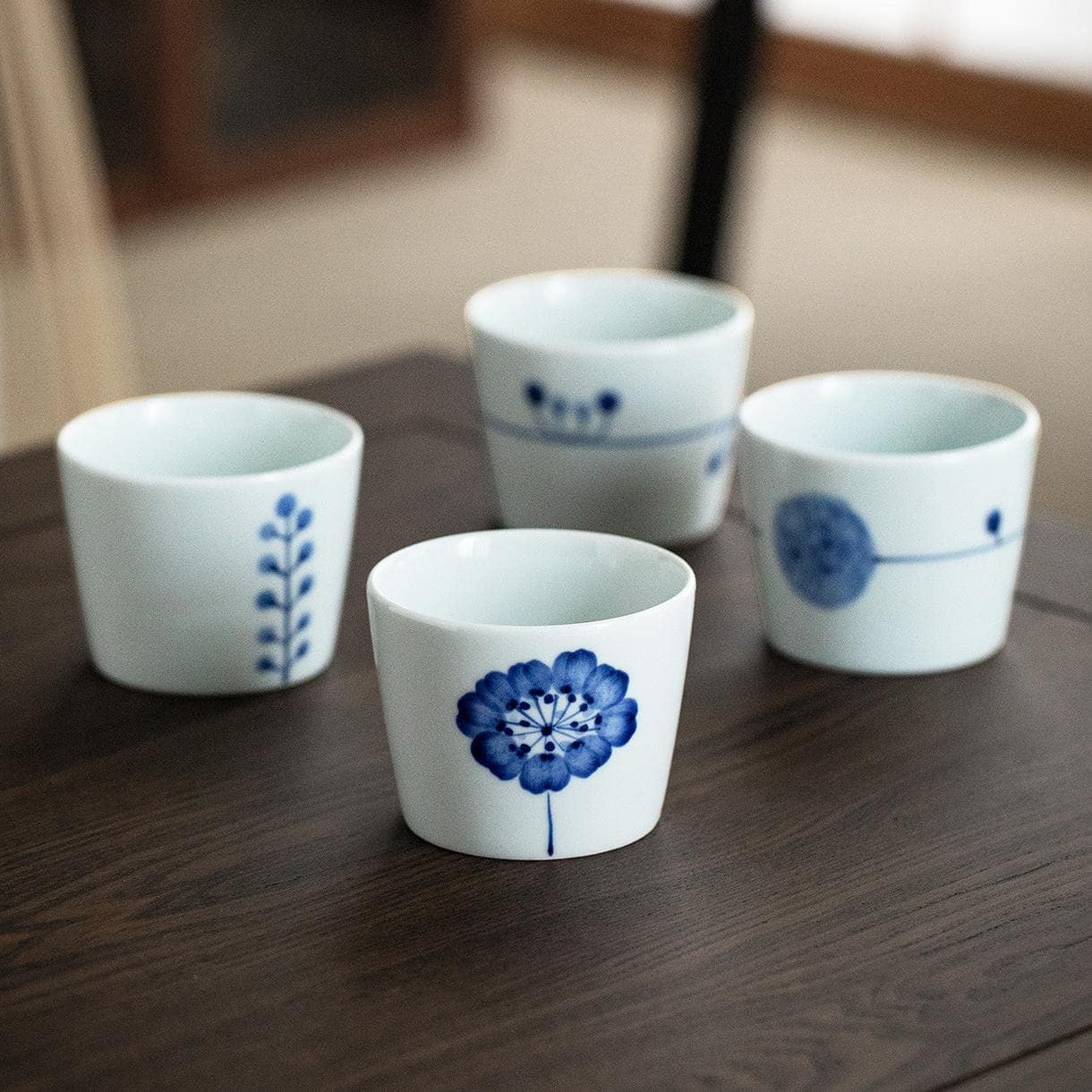 Set of Japanese blue and white porcelain tea cups on a wooden table.