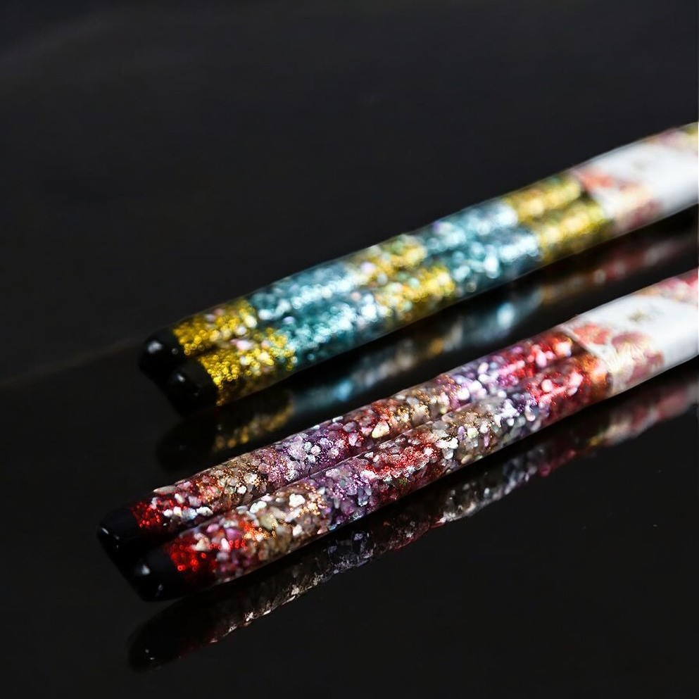 Close-up of premium chopsticks with shimmering floral design.