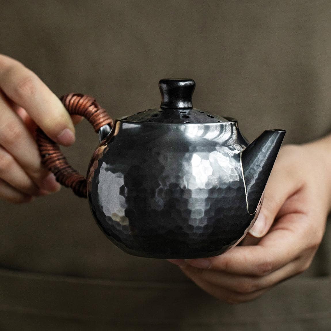 Stylish copper kettle with bamboo handle displayed on a wooden surface