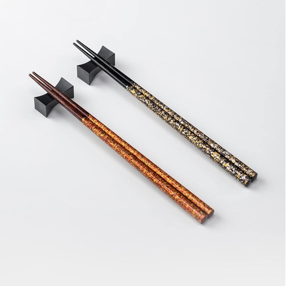 Two lacquered chopsticks sets displayed on minimalist holders