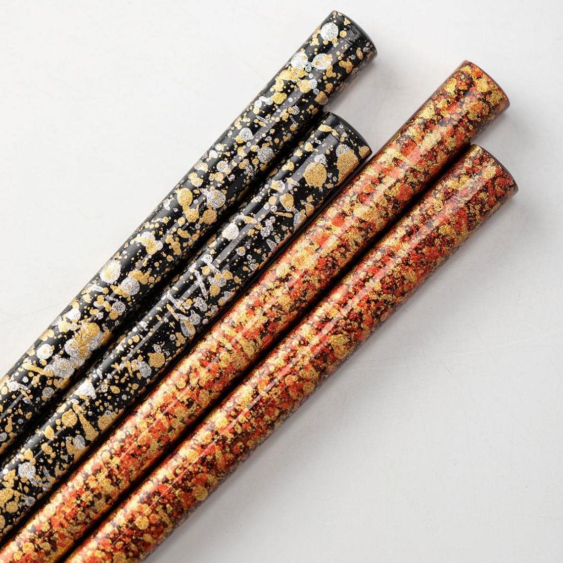 Single set of lacquered chopsticks with intricate gold design