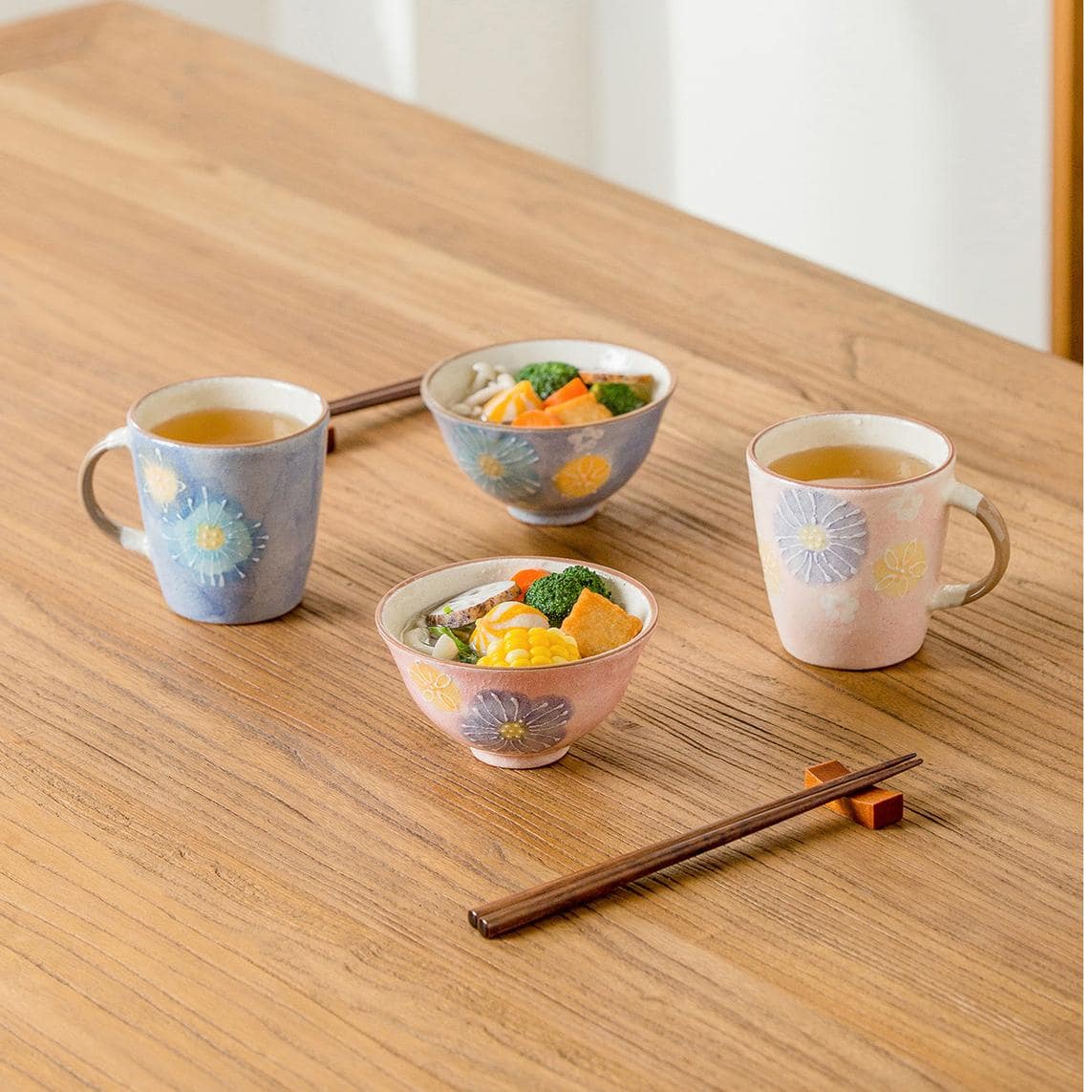 Hand-painted pastel ceramic cup with floral patterns on a wooden table