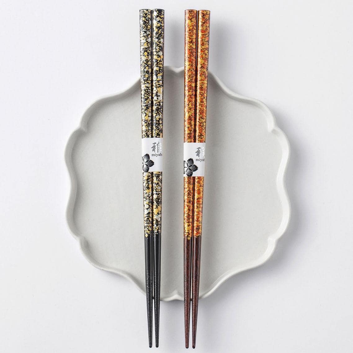 Two lacquered chopsticks sets displayed on minimalist holders