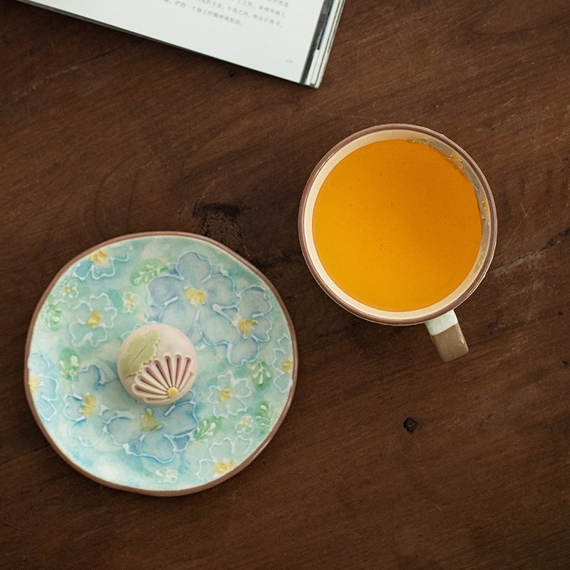 Soft pastel green and pink ceramic cup and saucer set