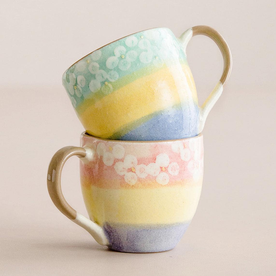 Set of artisan ceramic cups showcasing colorful gradients and floral details