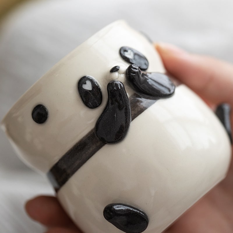 Adorable panda ceramic cup with expressive face and paw accents