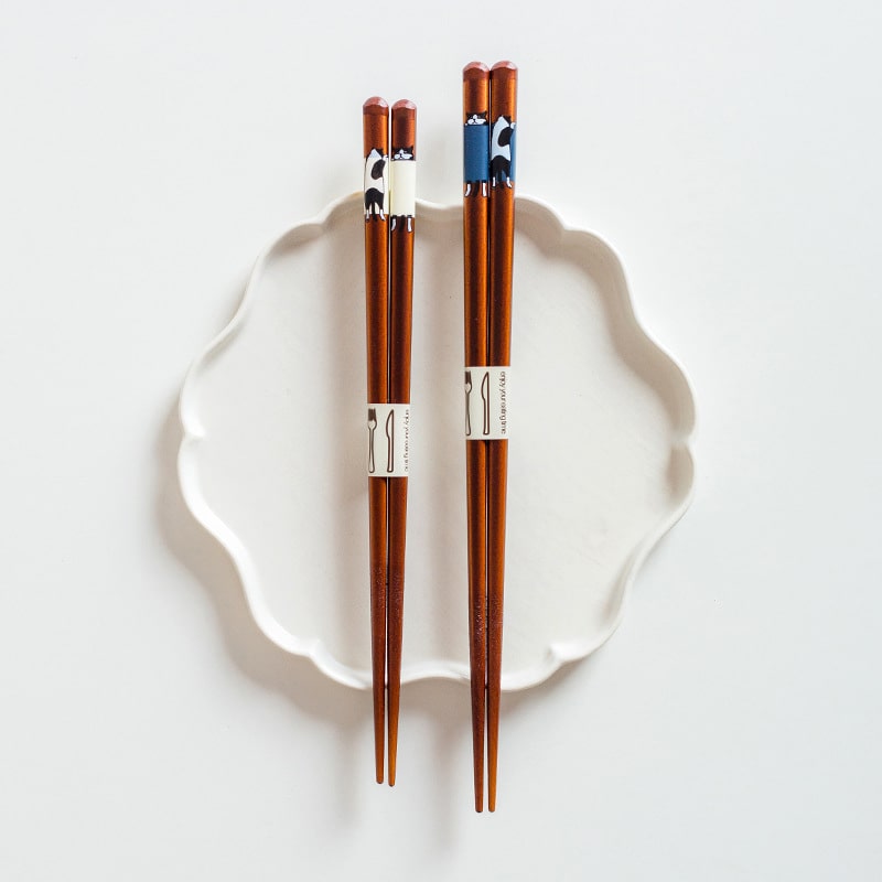 Cat-themed wooden chopsticks on white ceramic plate