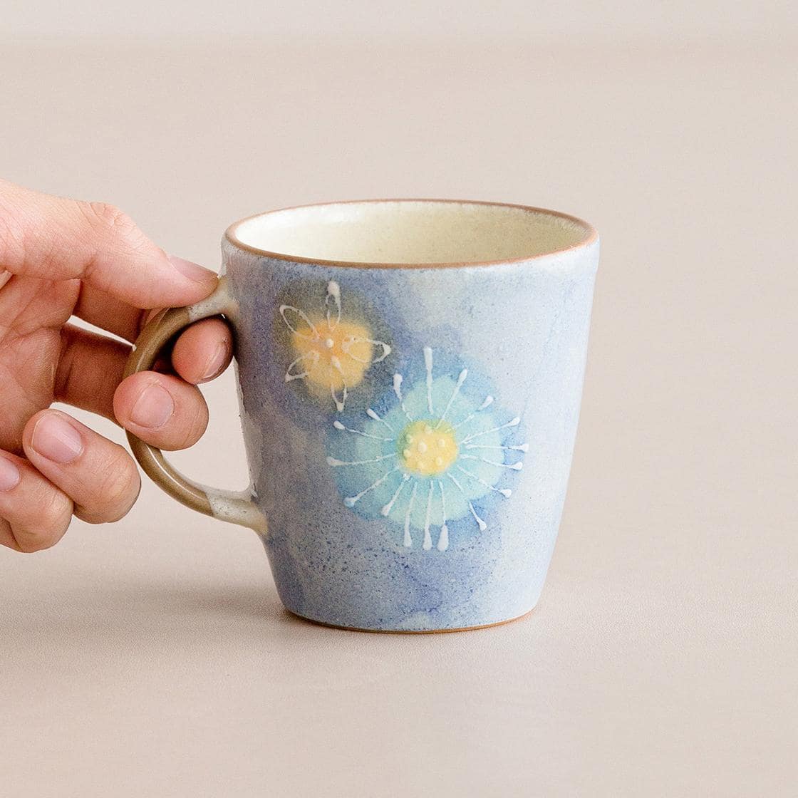 Pastel gradient ceramic cups with floral accents on display