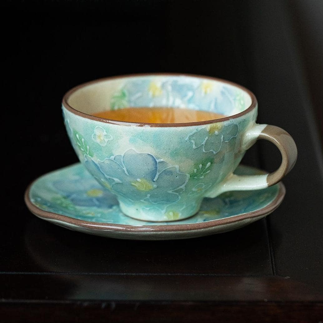 Handcrafted ceramic floral cup and saucer set on a table