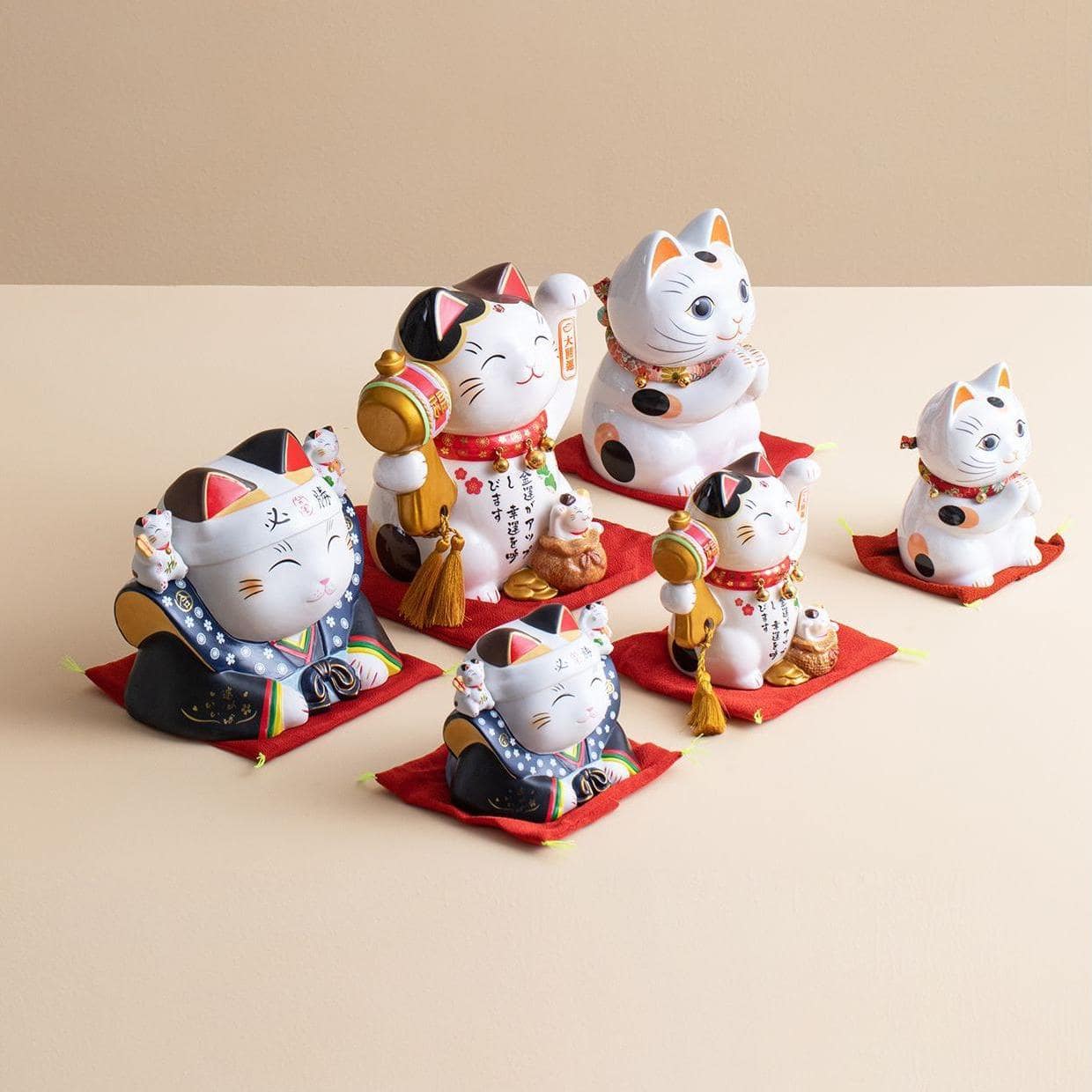 Japanese lucky cat ceramic decorations on a wooden table.