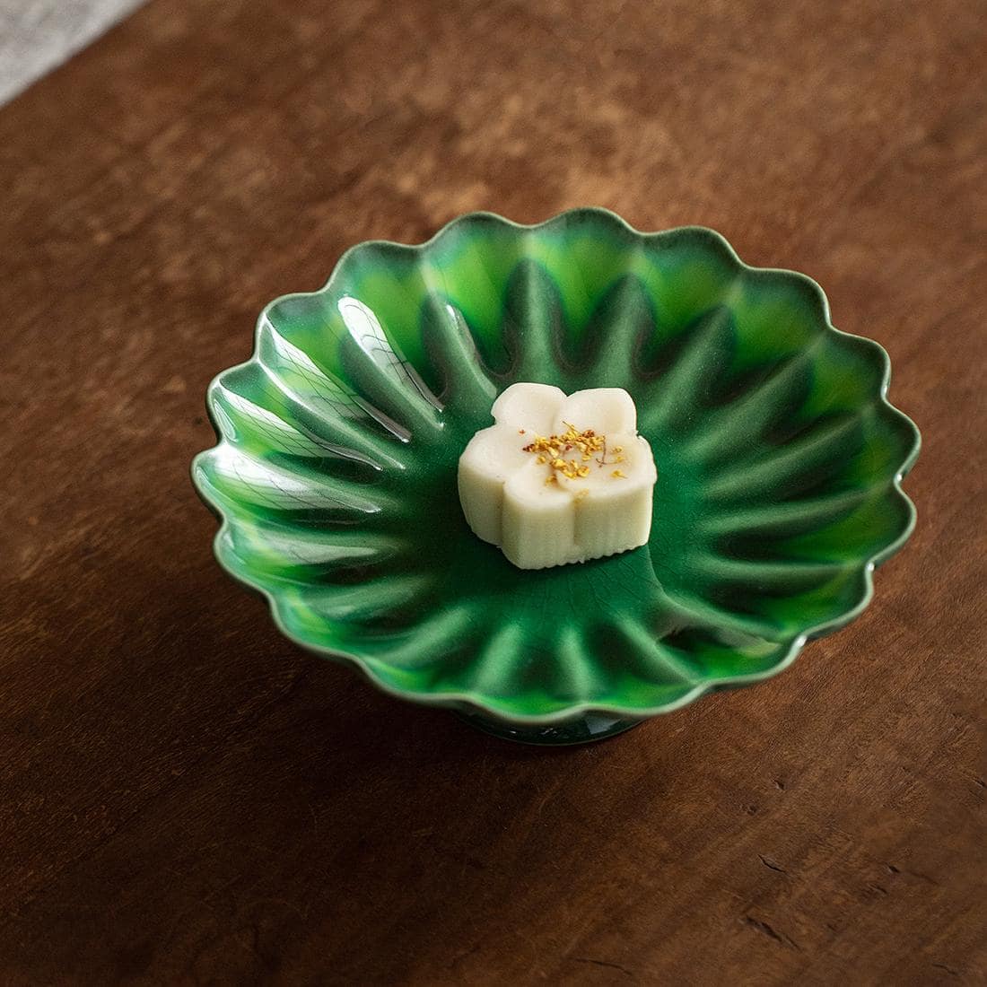 Close-up of chrysanthemum-shaped ceramic fruit plate with crackle glaze.