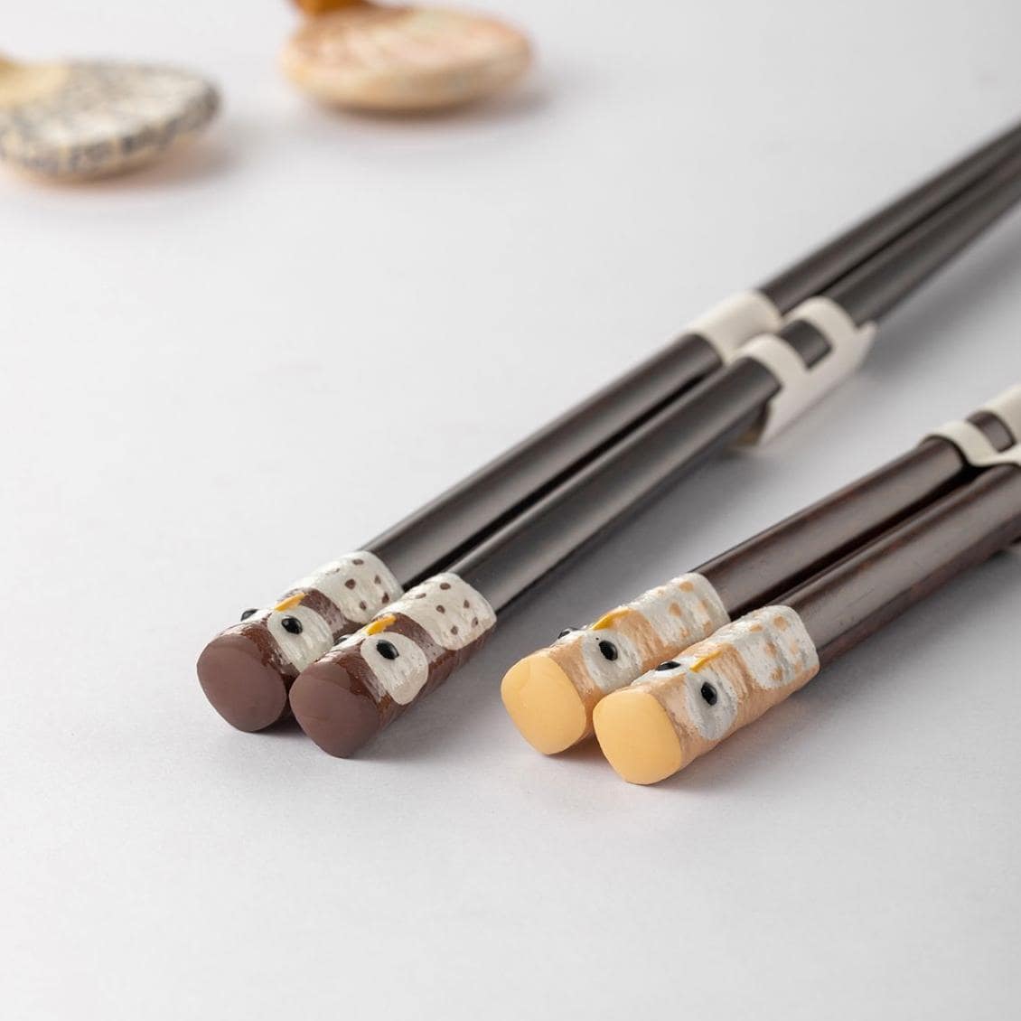 Natural wooden chopsticks with owl motif on a white plate