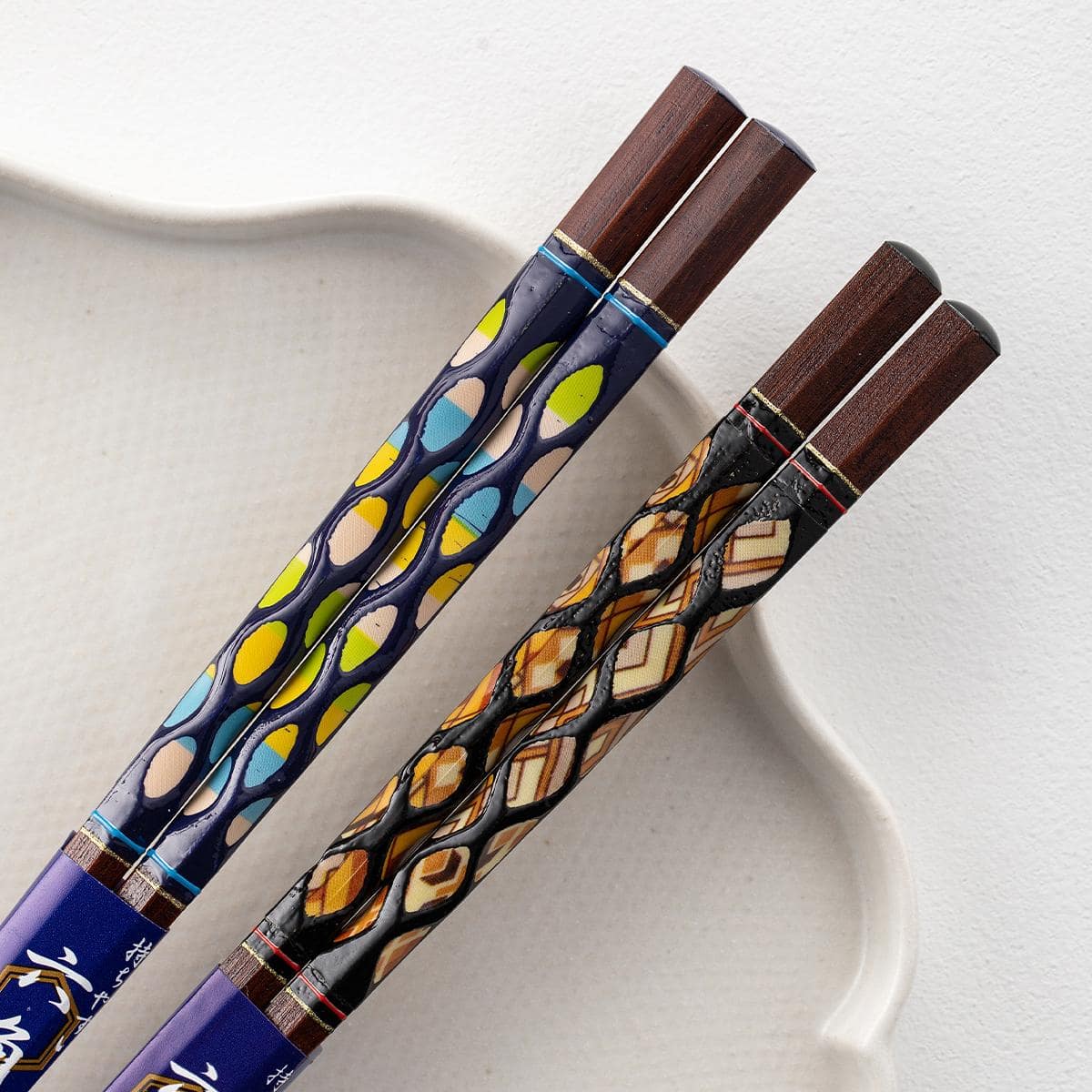 Stylish wooden chopsticks placed on a dining plate with vibrant patterns.