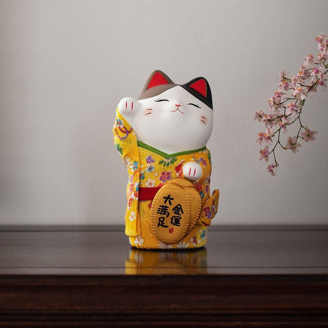 Collection of colorful Maneki Neko ceramic ornaments in traditional kimonos.