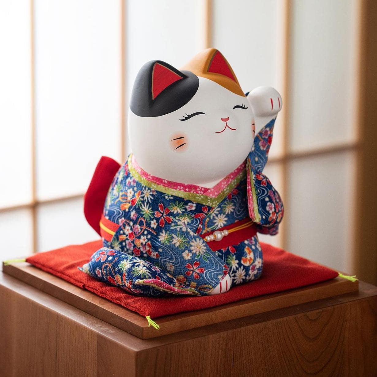 Handcrafted Japanese lucky cat figurine in a red kimono