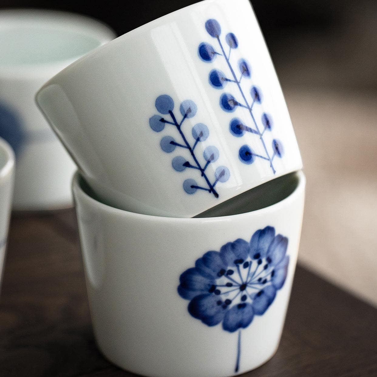 Individual blue and white tea cup with minimalist nature design.