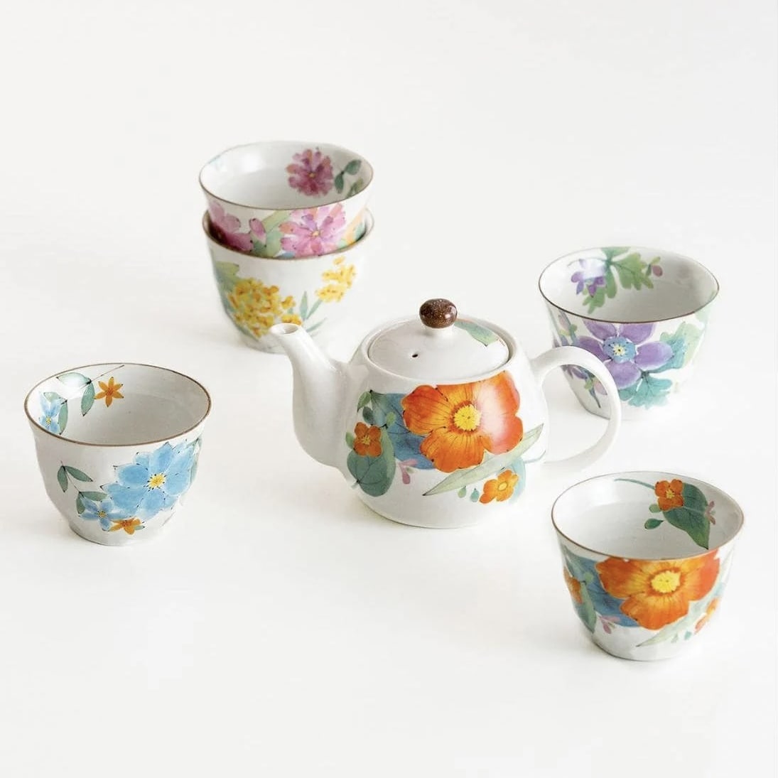 Collection of hand-painted floral teapot sets with cups