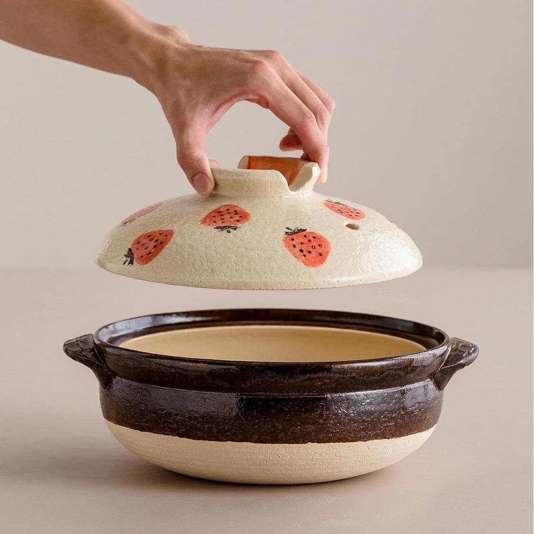 Handcrafted ceramic pot with strawberry design lid.