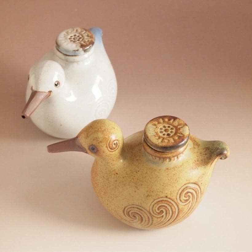 Close-up of zakka-style bird seasoning bottle on a kitchen table.