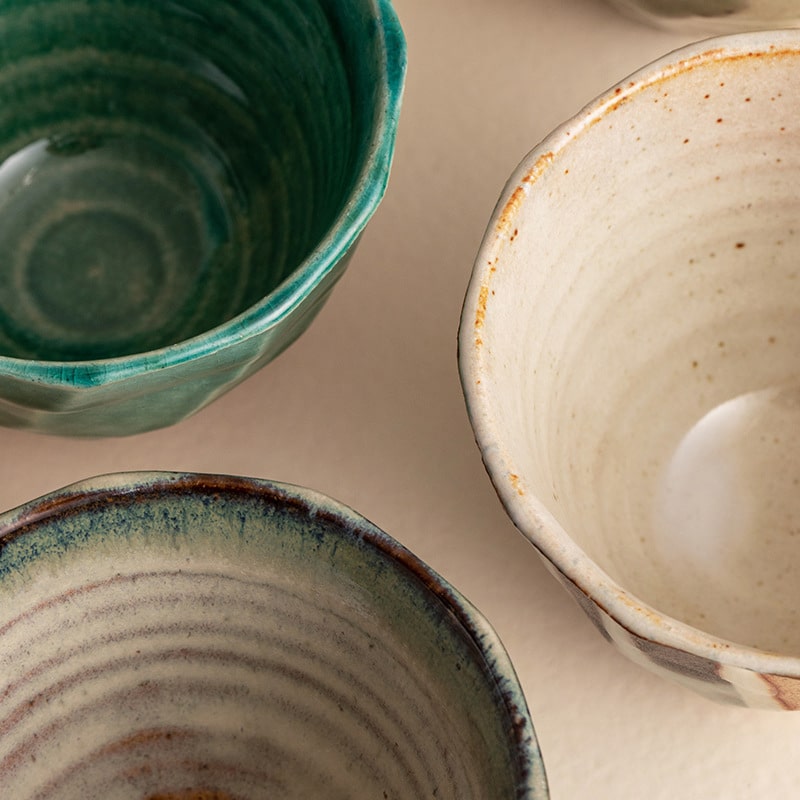 Close-up of Japanese pottery cups with unique glaze textures