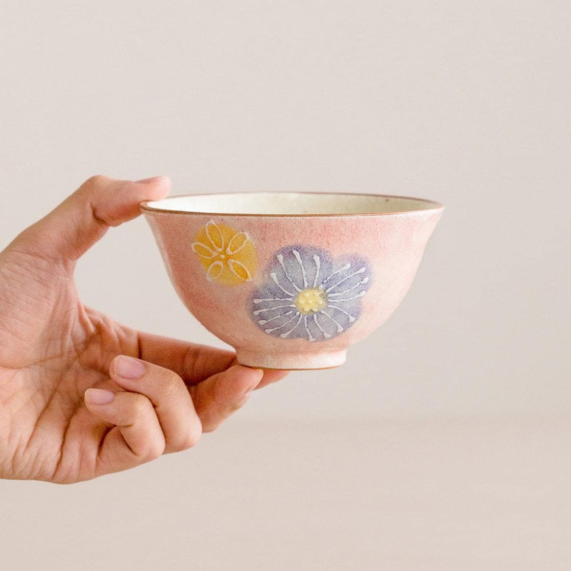 Soft pastel Japanese bowls showcasing yellow and lavender floral detailing