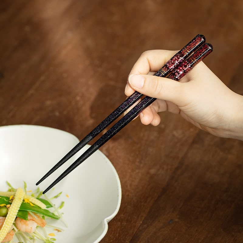 Elegant Japanese wooden chopsticks with red and black accents.