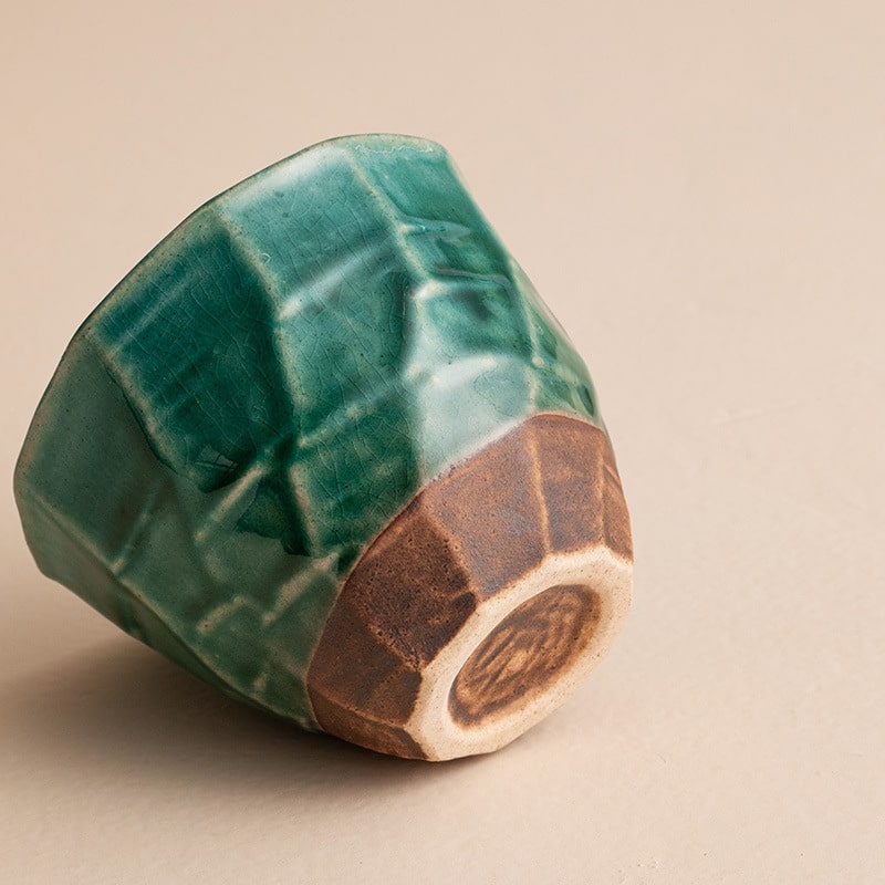 Single green ceramic cup showcasing intricate craftsmanship