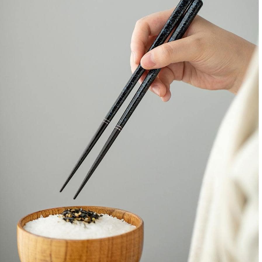 Two lacquered chopsticks sets displayed on minimalist holders