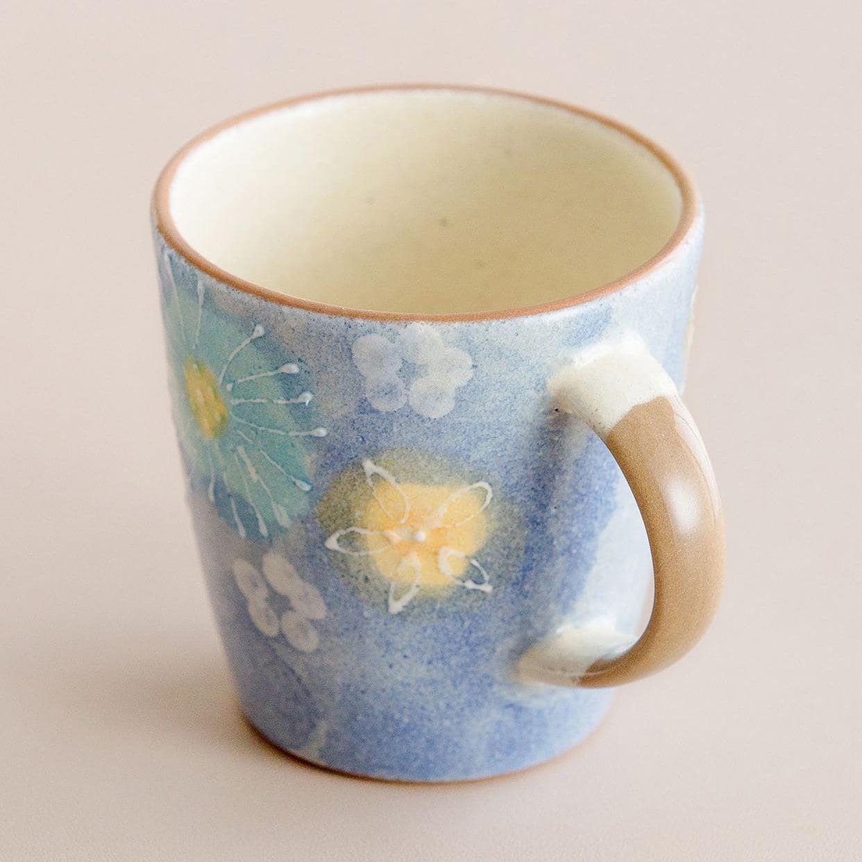 Set of artisan ceramic cups showcasing colorful gradients and floral details