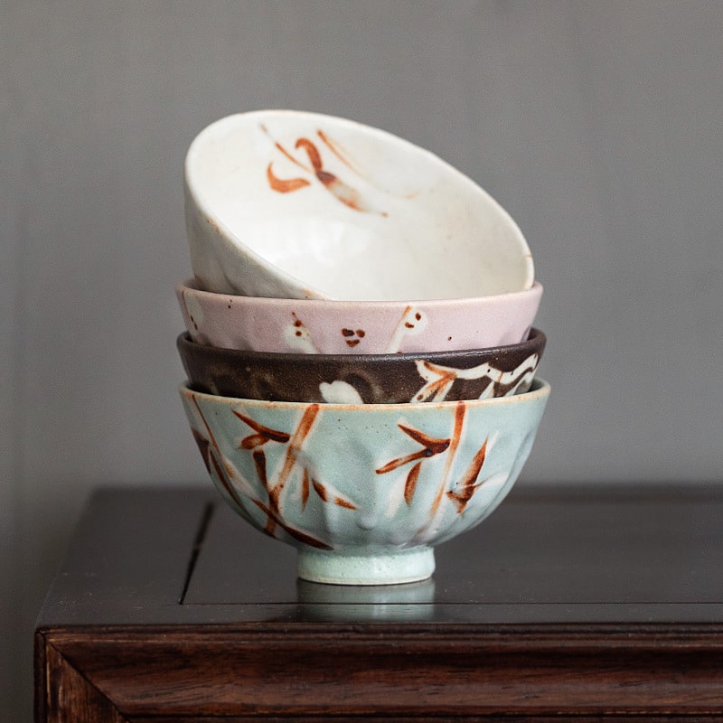 Hand holding a ceramic bowl highlighting its intricate details.